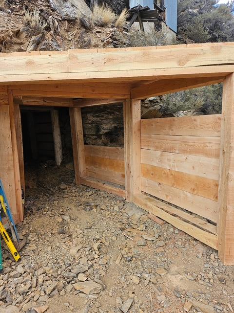 A wooden structure with a door open AI-generated content may be incorrect.