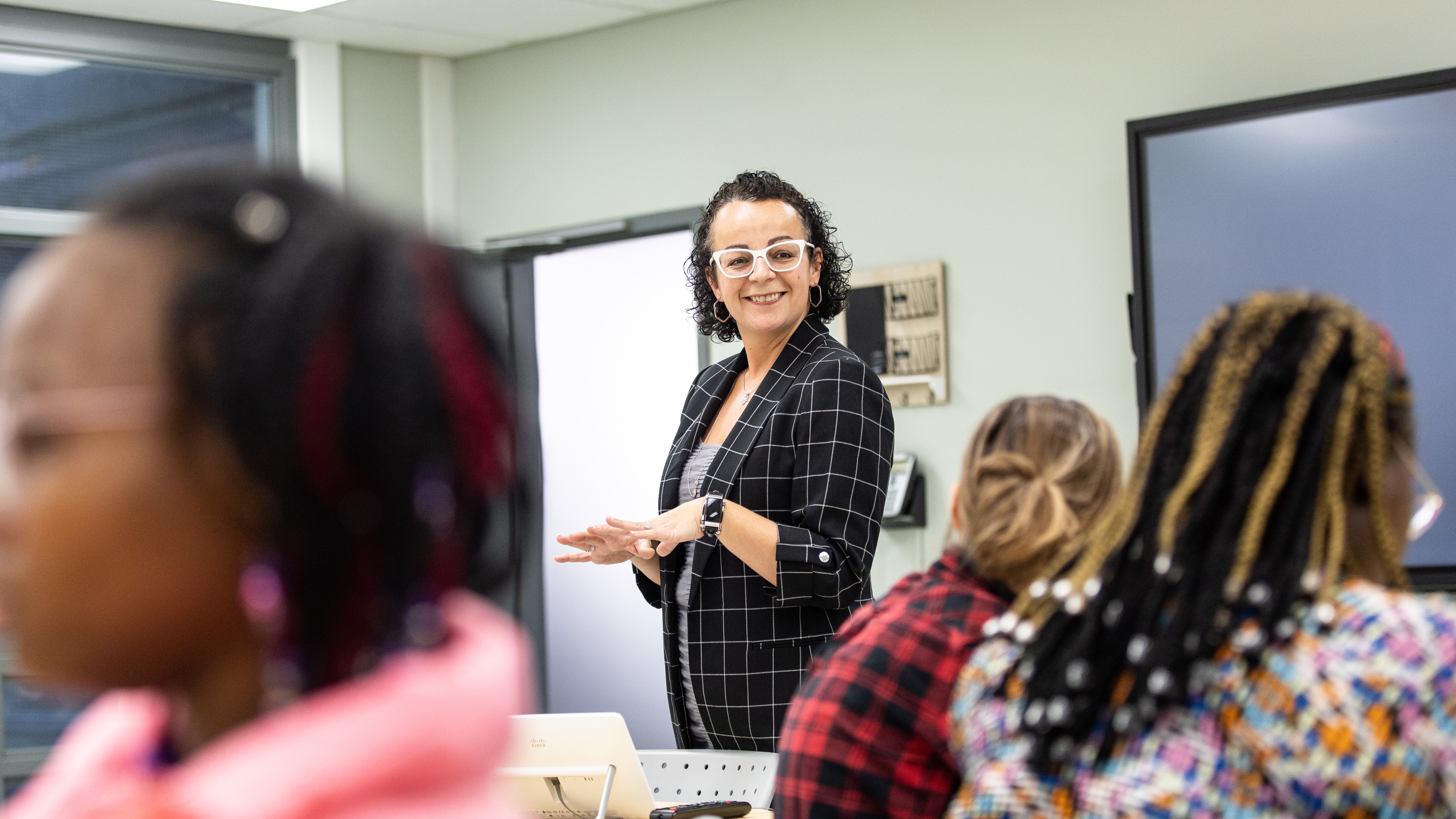 A smiling professor is teaching in an early childhood education class.