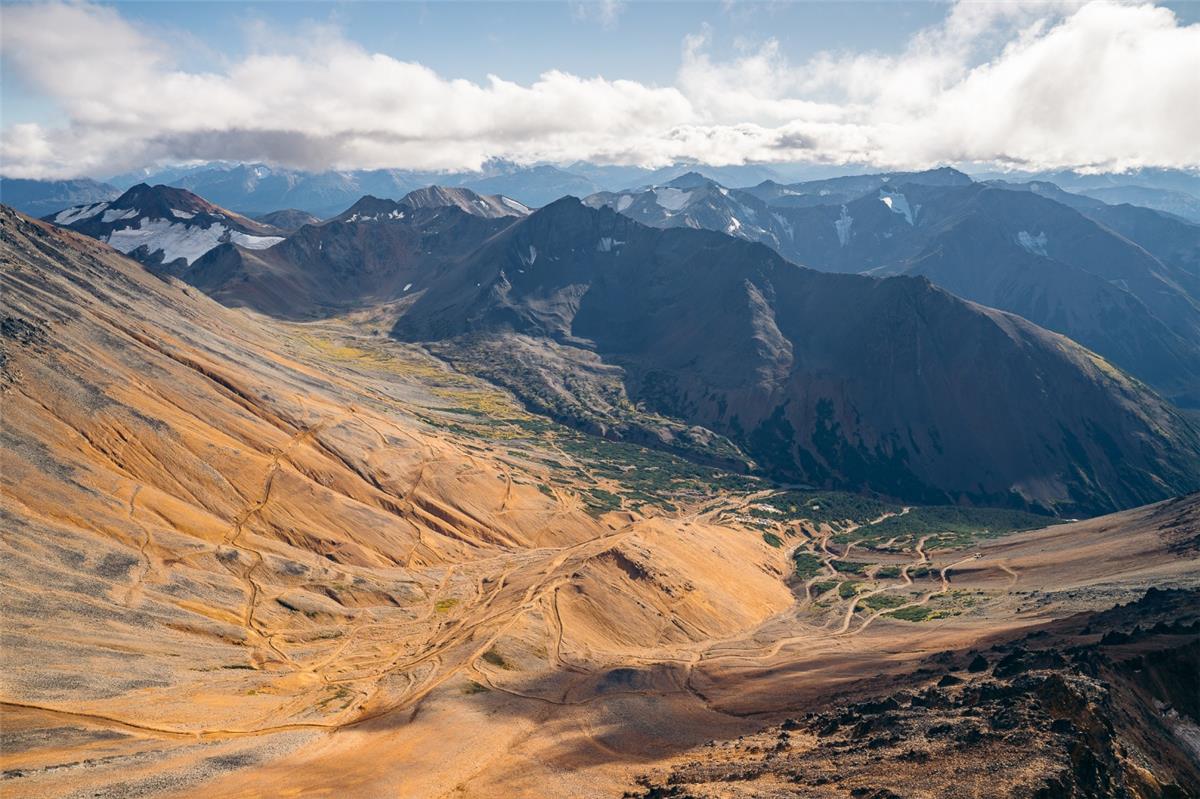 A mountain range with snow and clouds AI-generated content may be incorrect.
