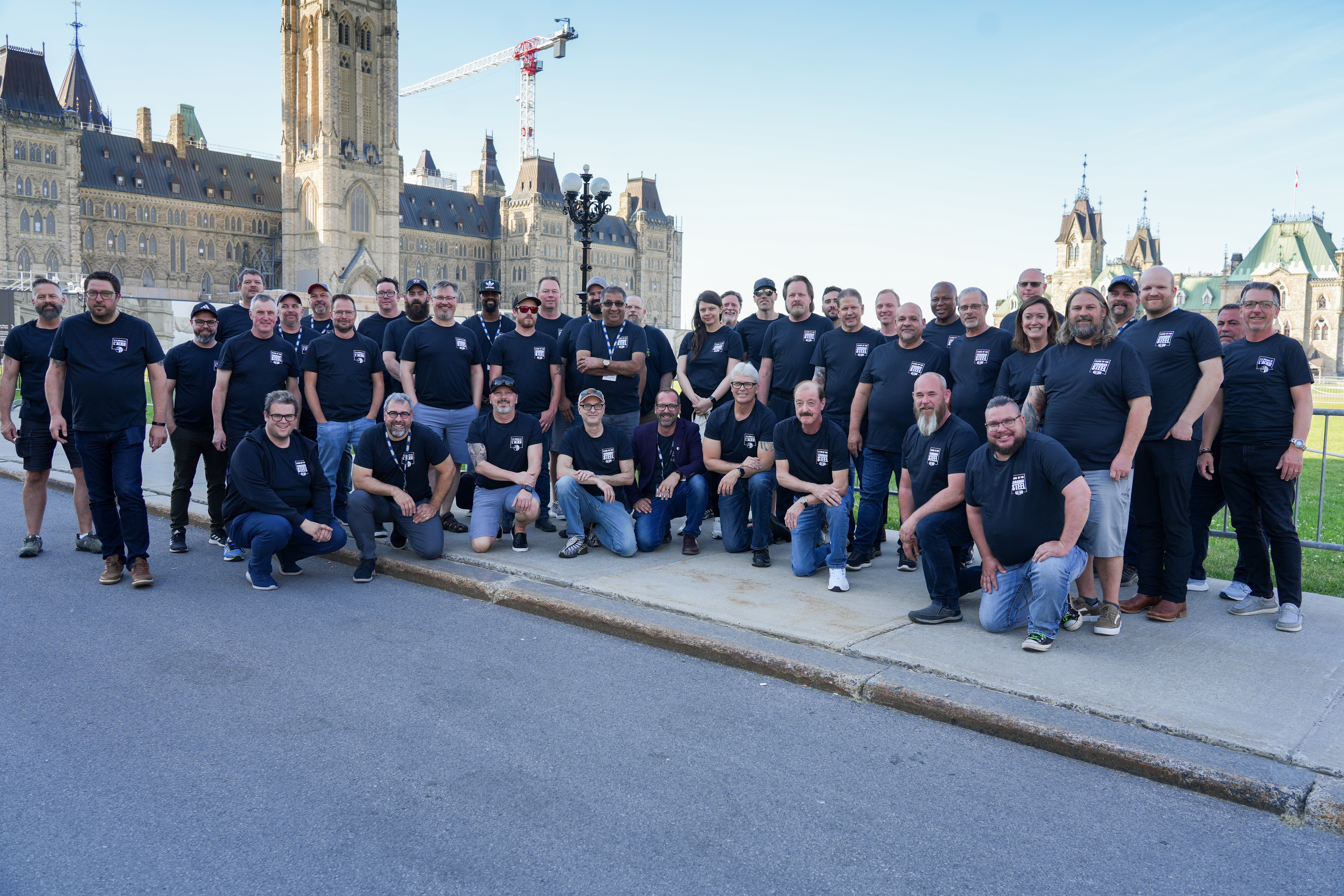 A group of people gather outdoors on Parliament Hill.